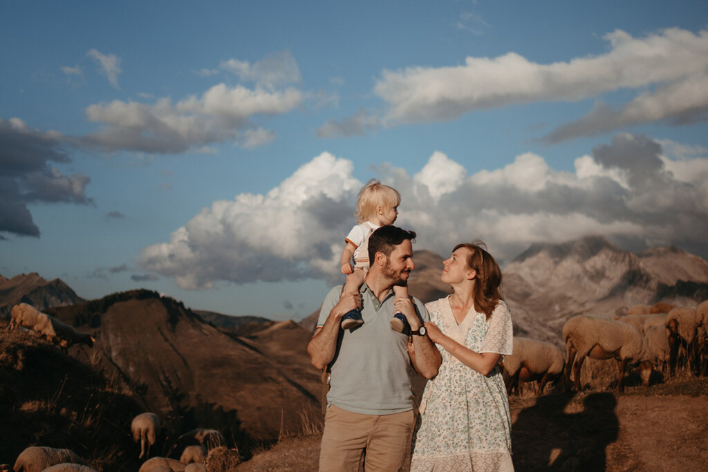 Reuben and Polly, the founders of retreat to the alps, with their little son on a mountain in the Alps