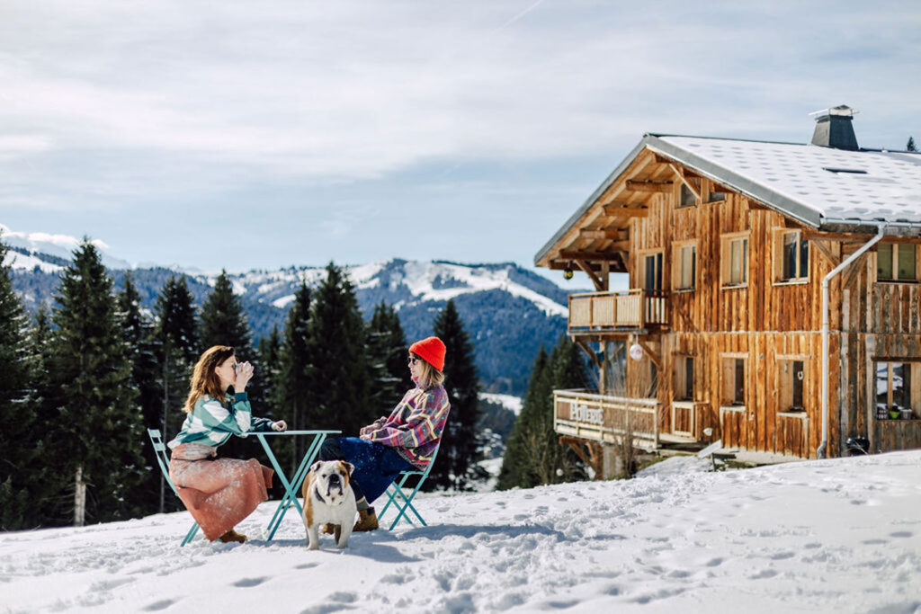 Two sisters having coffee in winter in the Alps