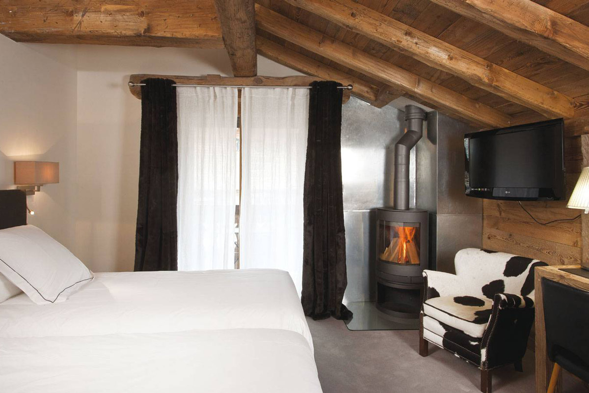 Bedroom with a fireplace in hotel in Les Gets