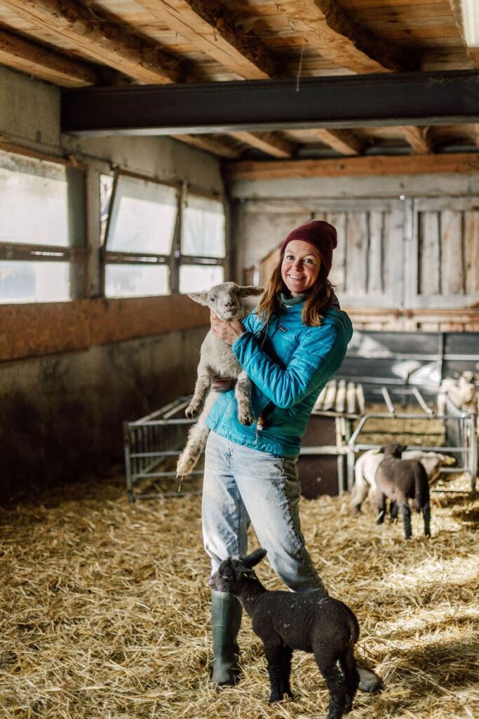 Anouk with a little sheep in the farm in the Alps