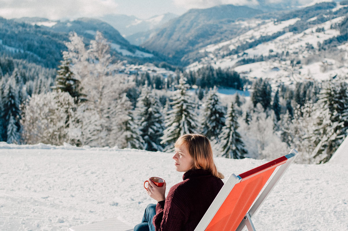 Woman drinks coffee in winter mountains