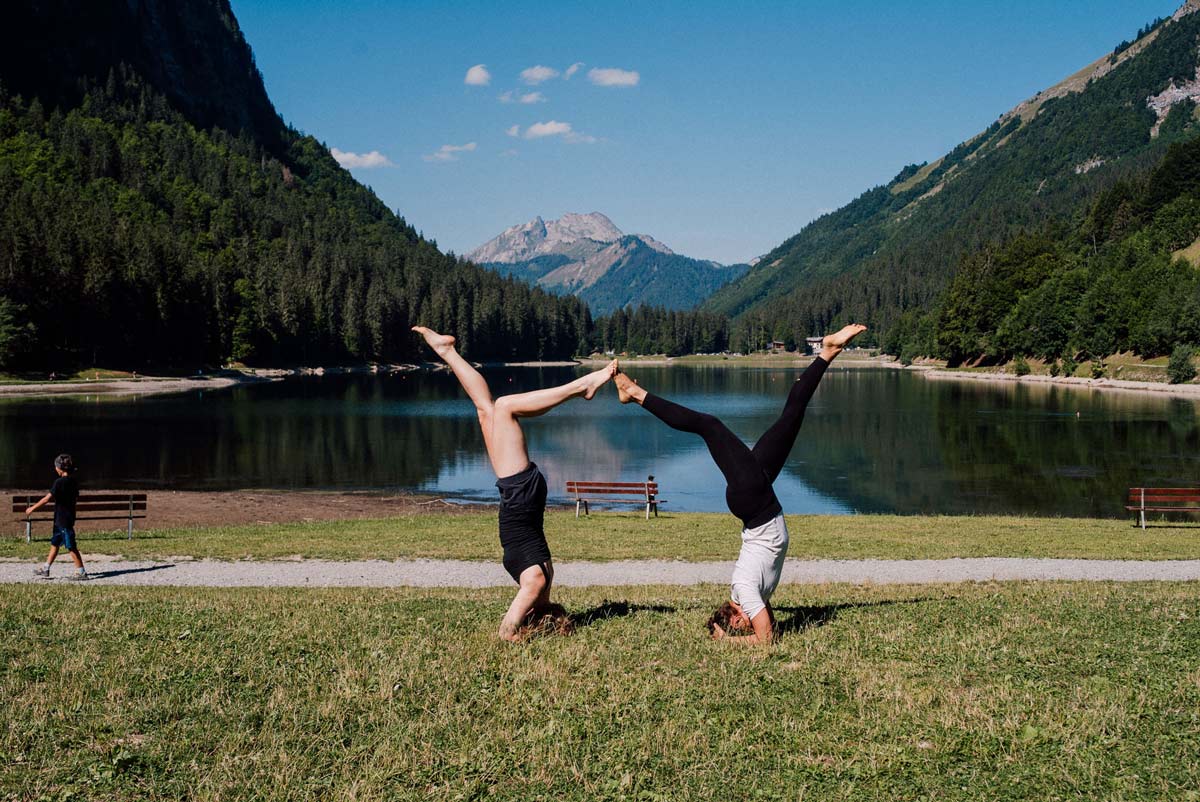 mother and daughter retreat yoga in front of the lake in Morzine