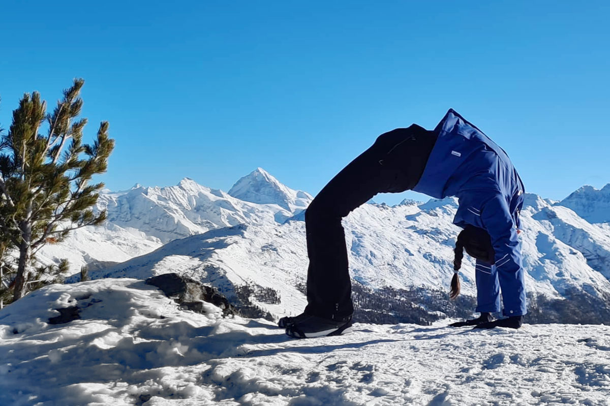 Claudia Lamas Cornejo practising yoga on a hike in the snowy mountains in the Alps