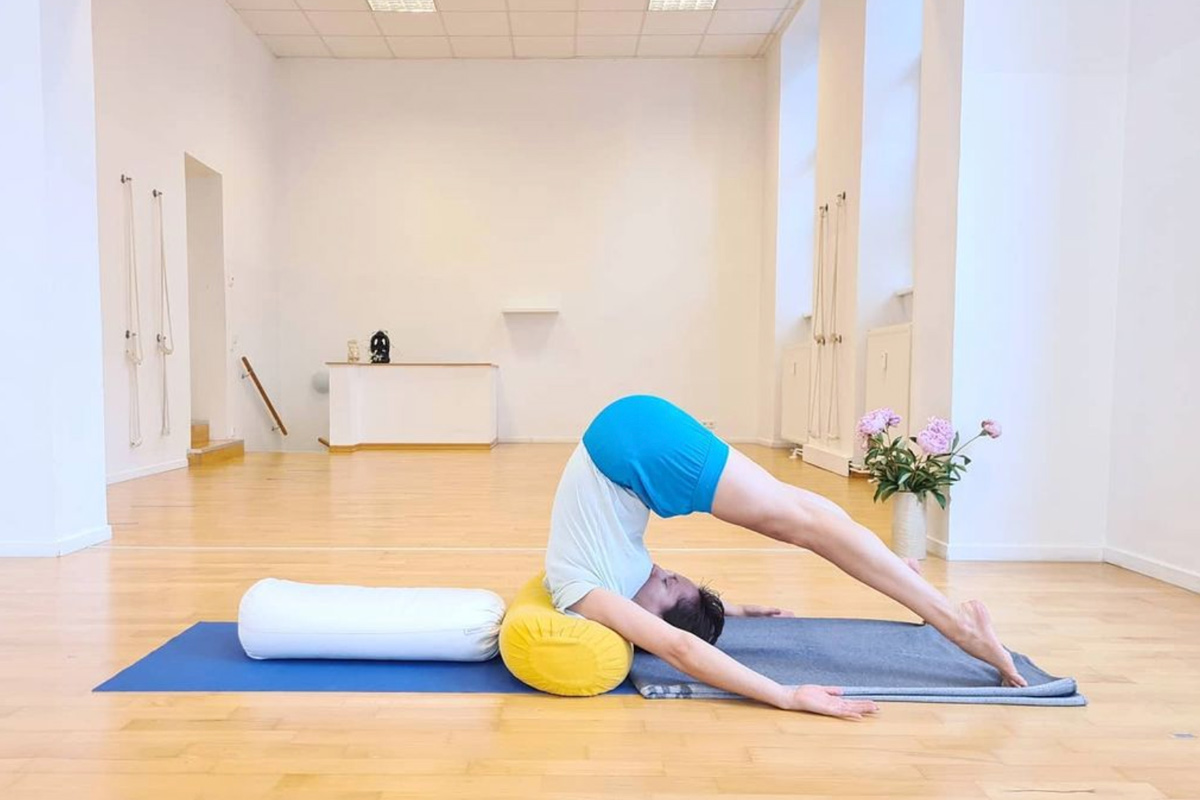 Claudia Lamas Cornejo using a bolster to practise Iyengar yoga